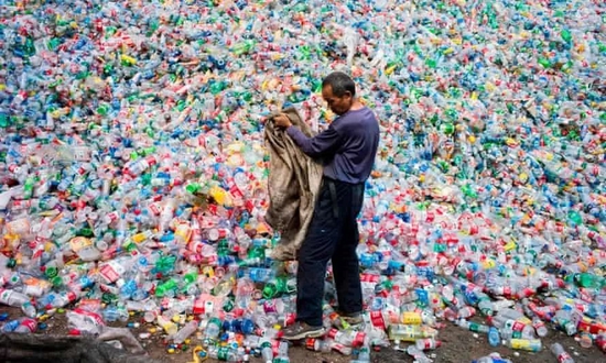 图中的中年男子正分类回收塑料瓶